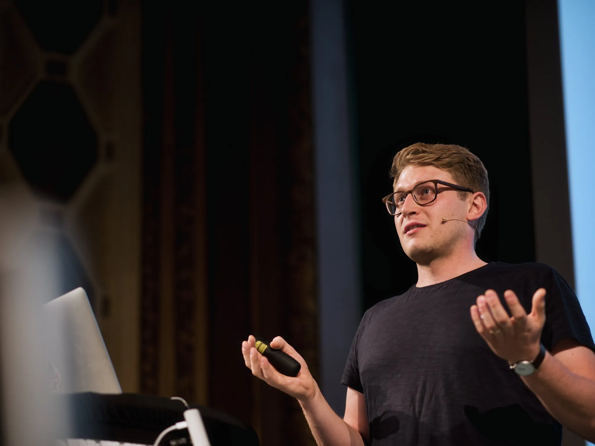 Samuel Snopko speaking at a conference, pointing at a slide